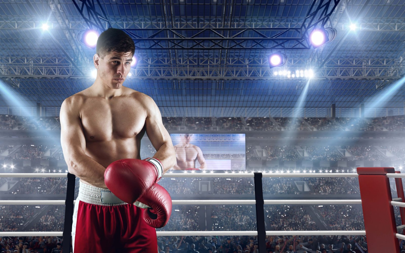 A professional boxer in a red and white uniform standing in a brightly lit boxing ring, preparing for a match with a stadium crowd in the background.